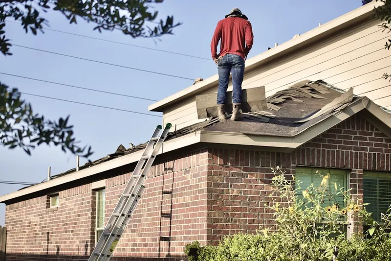 Professional roofer working on a residential roof in Aldens